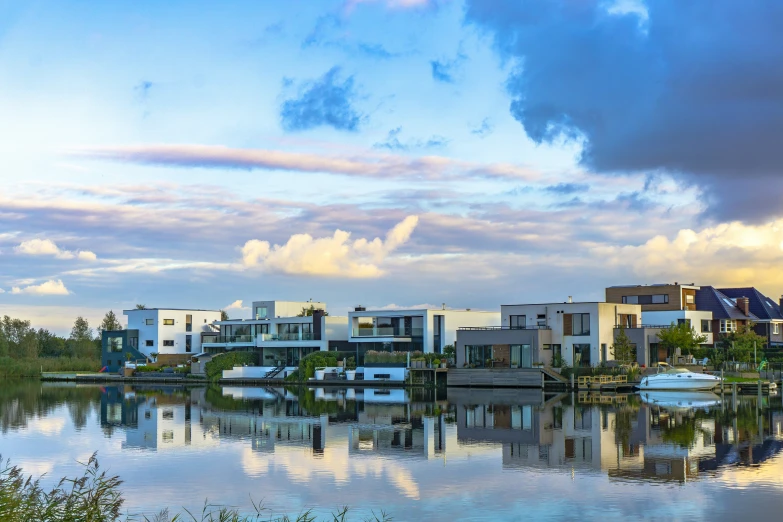 several houses are reflected in a body of water