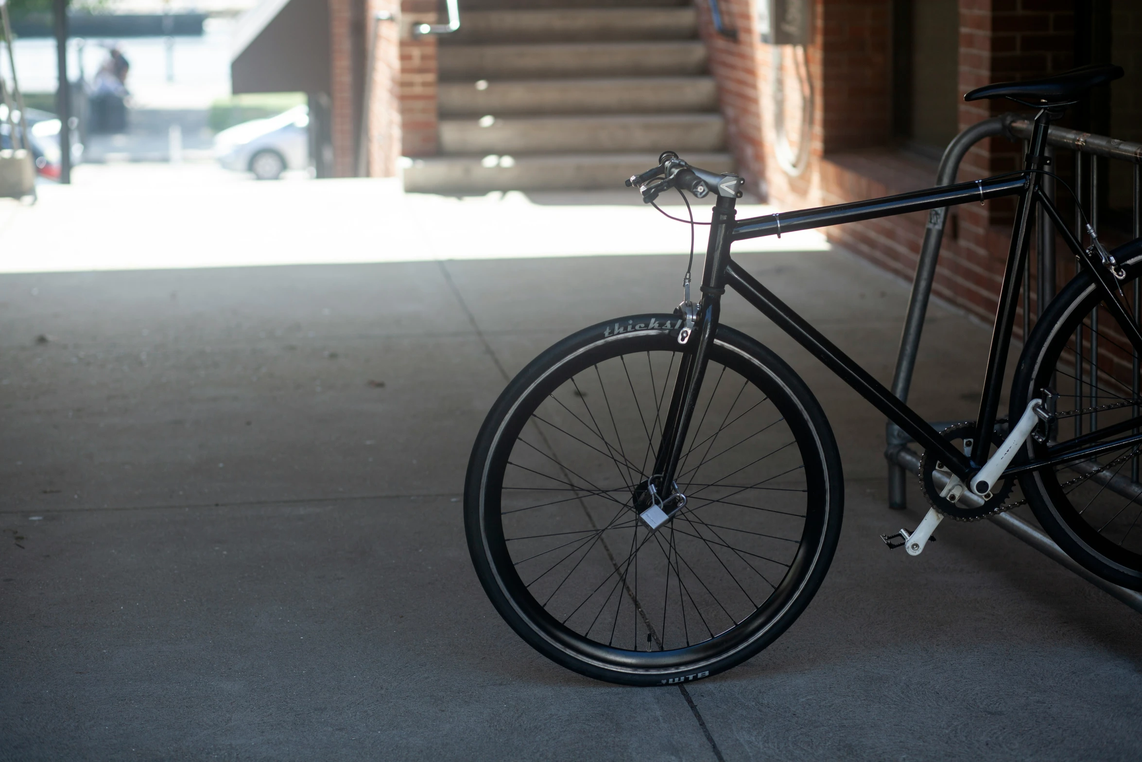 bicycle parked next to a rail in front of an entrance