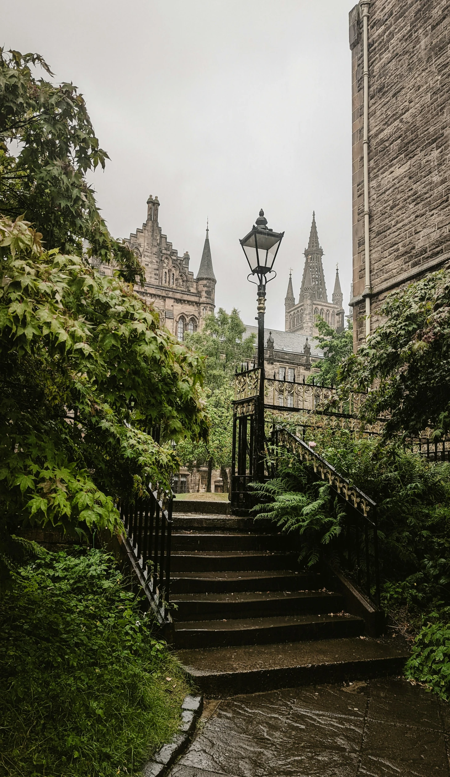 an old street lamp, with stone building behind it