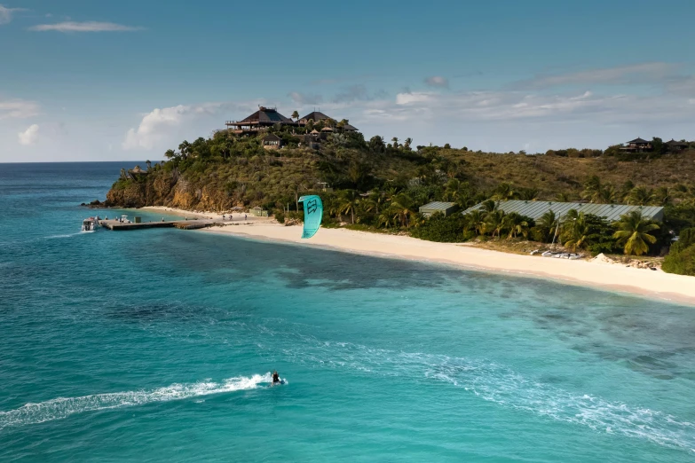 a water skier riding near an island on a clear day