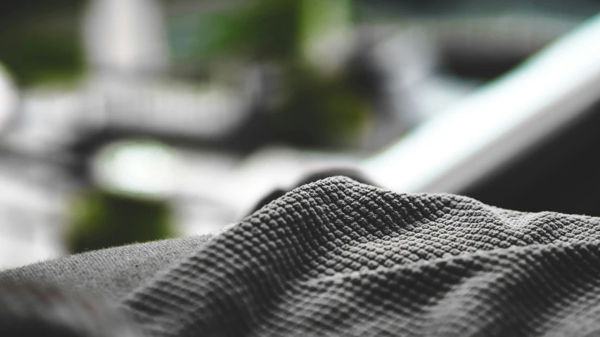 a grey t - shirt on a wooden table next to some plants