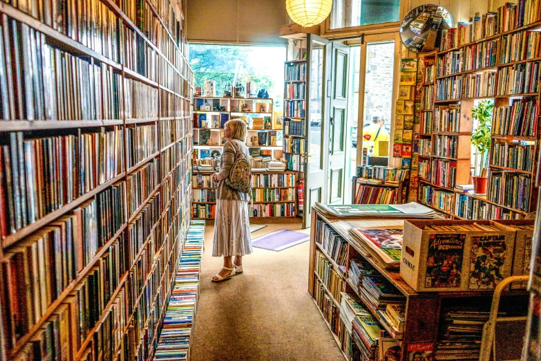 a man walking in between two rows of books