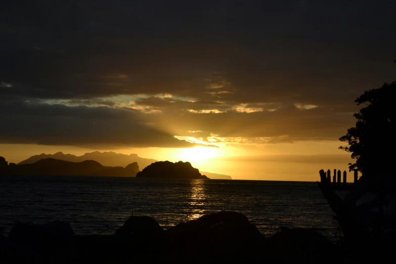 a small island and large rocks at sunset