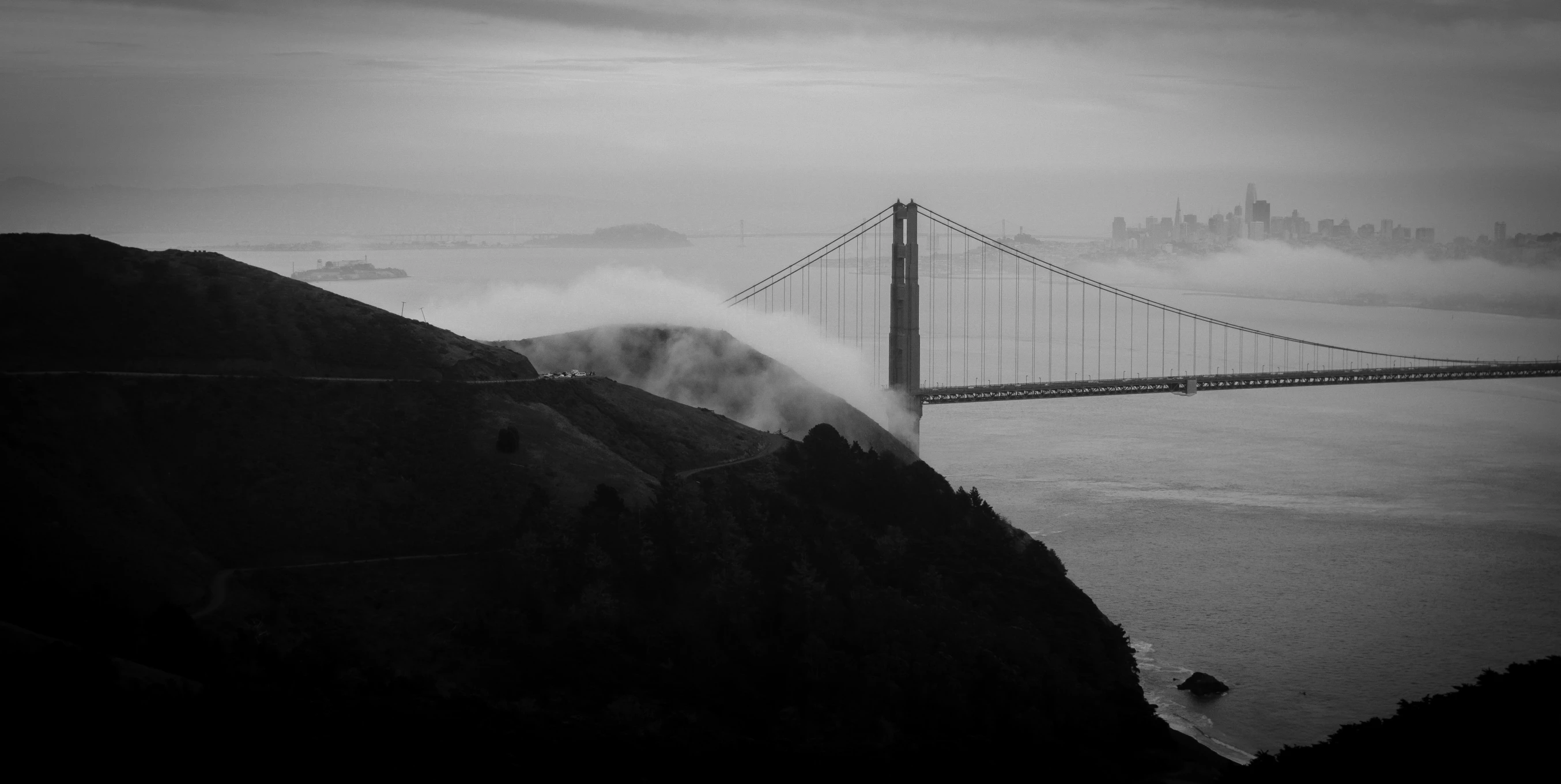 the golden gate bridge over looking the water in fog