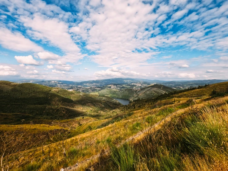 a wide open mountain valley with hills and small towns in the distance