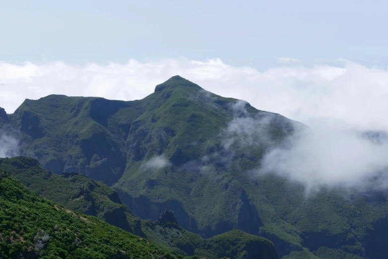 a very tall mountain with green foliage on it