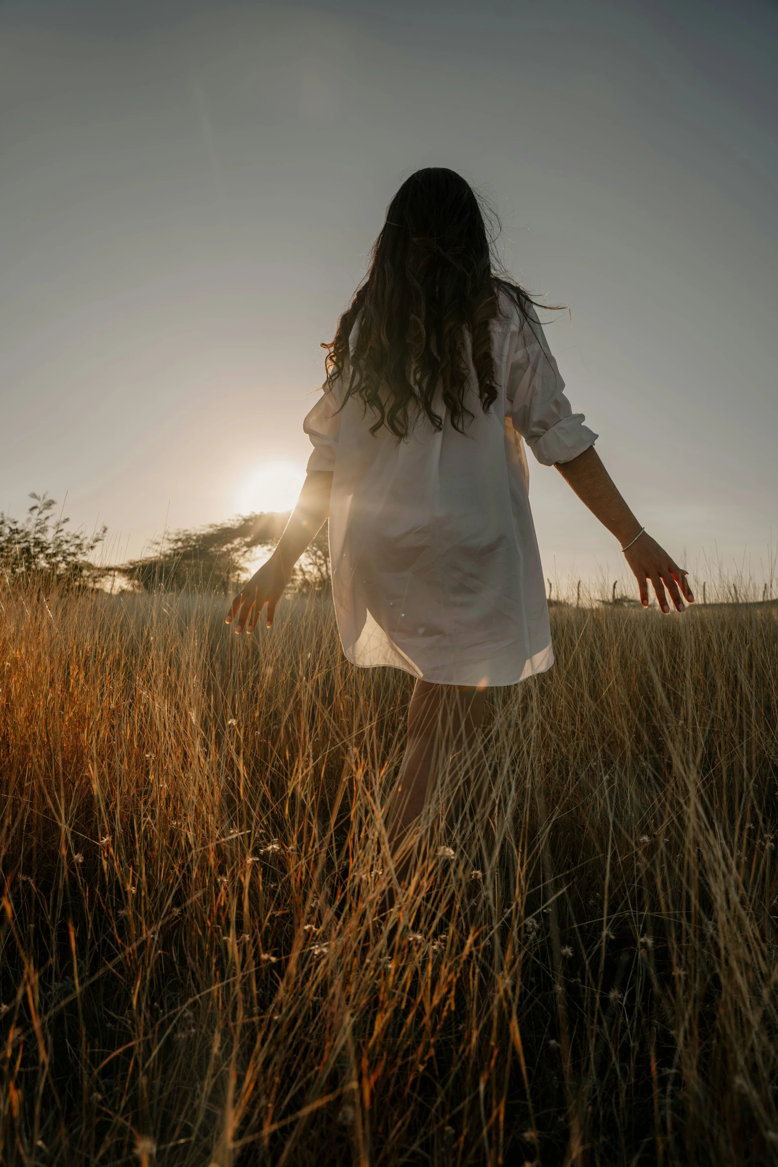 an image of a girl walking away from the sunset