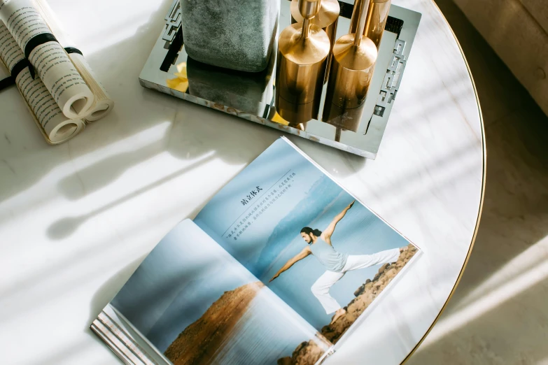 a book on a coffee table next to magazines