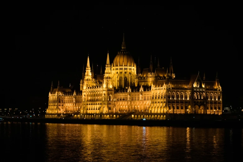 illuminated castle on a lake at night with water reflecting