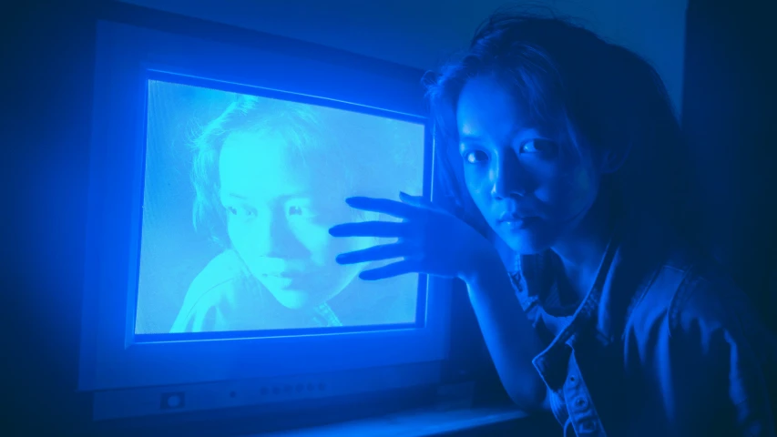 a woman in a dark room with a tv screen