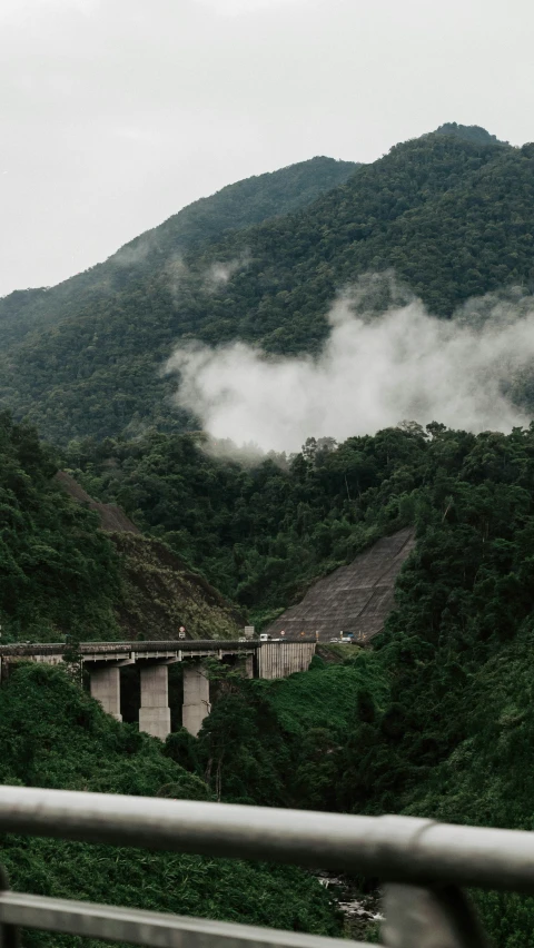 fog over the bridge above some hills