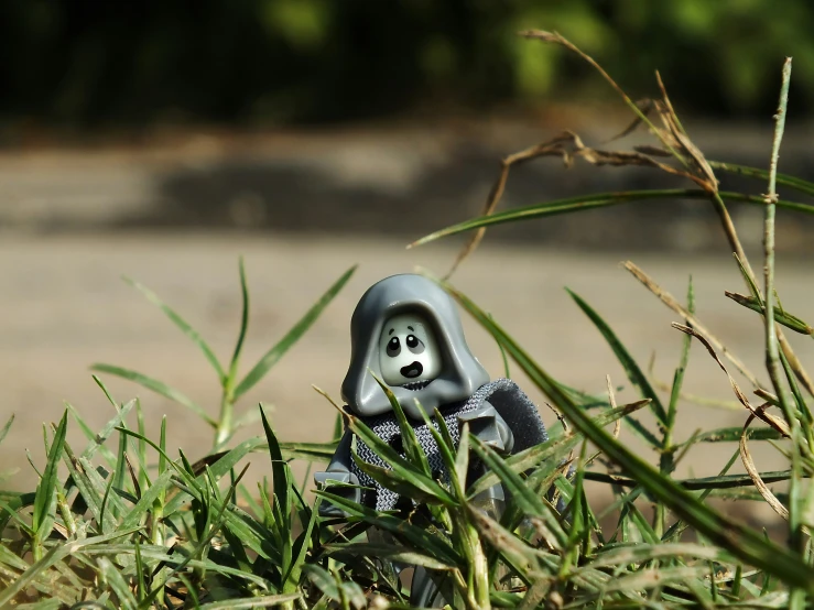 small blue and black ceramic figure sitting in green grass