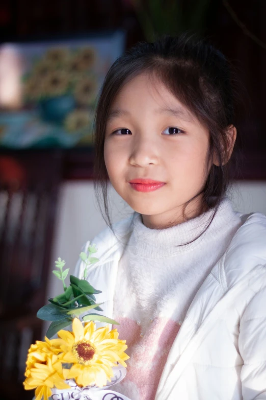 a girl holding a vase with yellow flowers in it