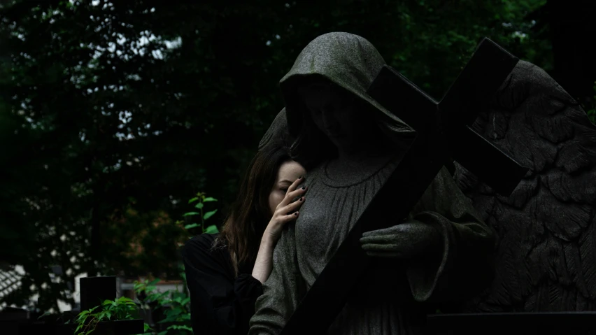 a woman talking on her phone standing next to a statue