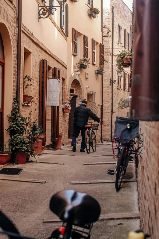 people walk down a narrow alley lined with older buildings