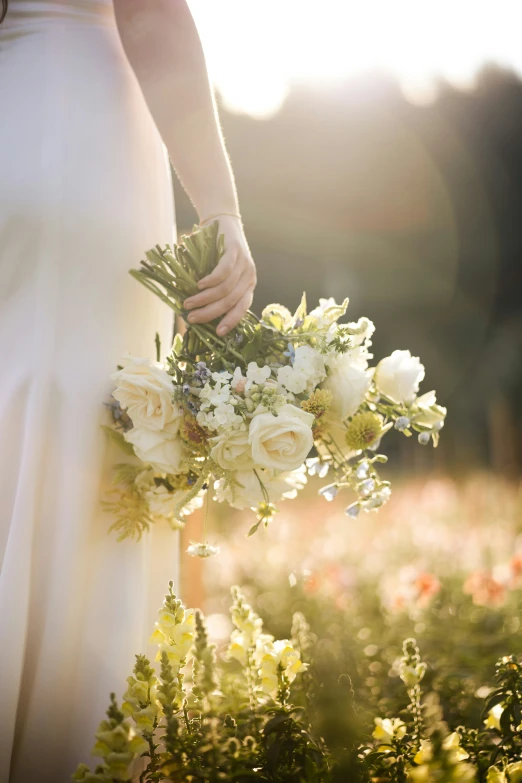 a woman holding a bouquet in the middle of flowers