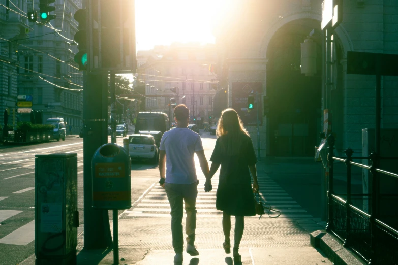 a man and woman walking down a street holding hands