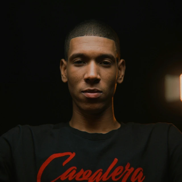 a man wearing a black shirt with a red t - shirt on and the word causalero on it