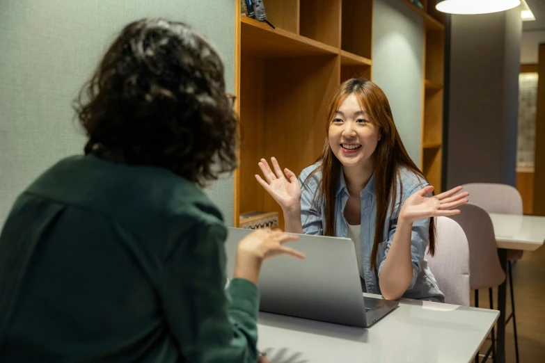 two women in a office with a laptop in front of them