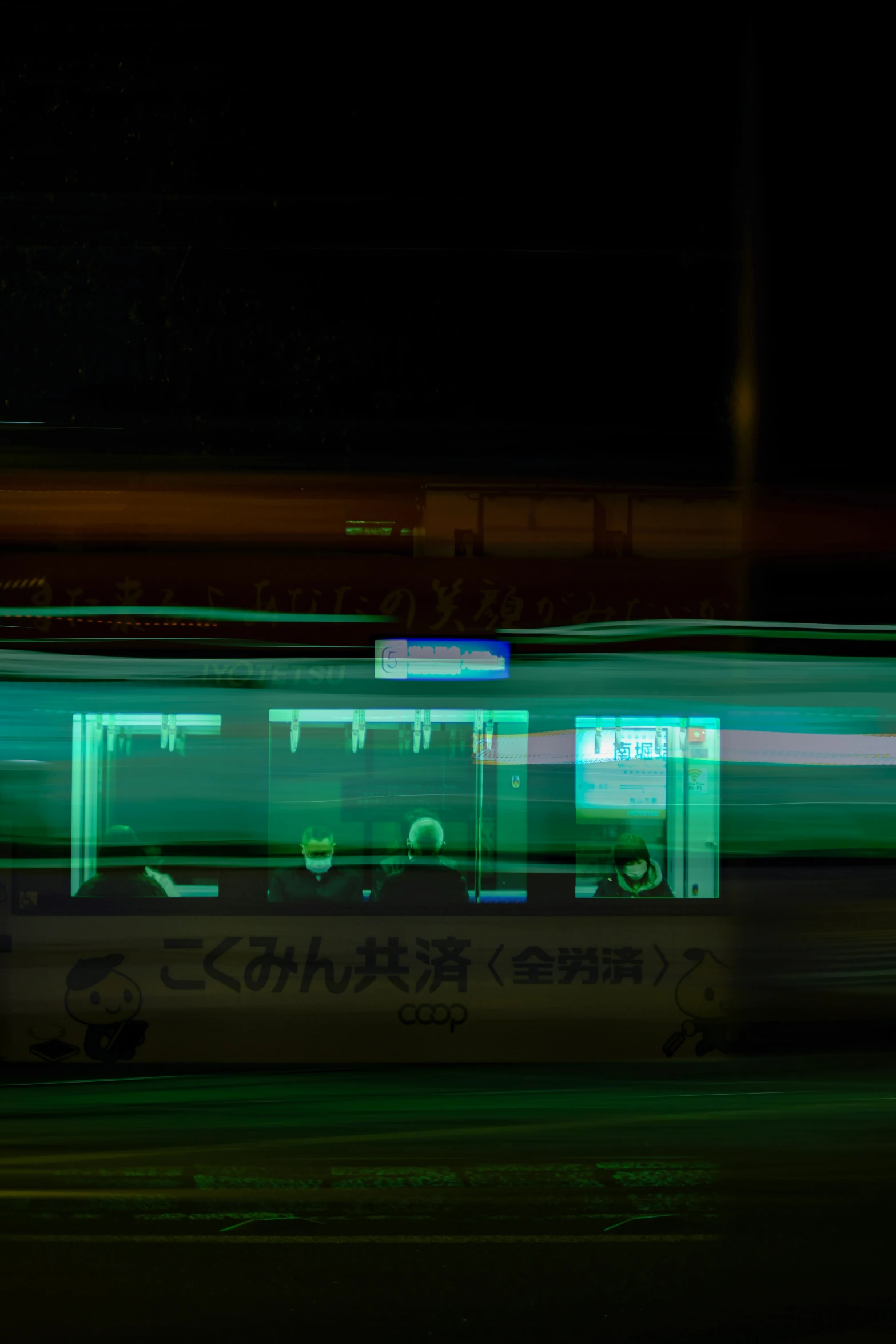 the bus is driving down the street at night