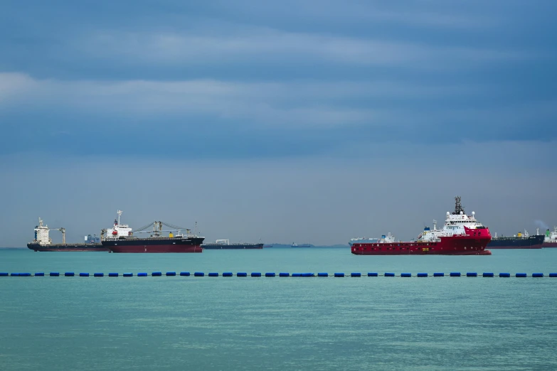 three large cargo ships on the water