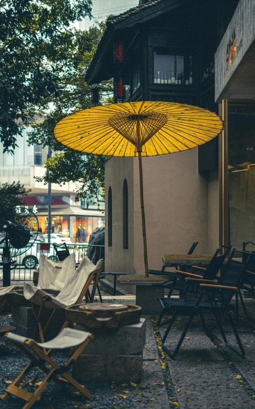 the yellow umbrella is sitting on the outside patio