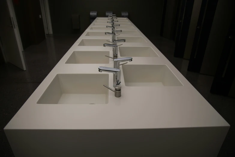 a long counter top with many square sink