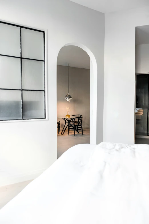 white bed in modern home with glass windows in the bedroom