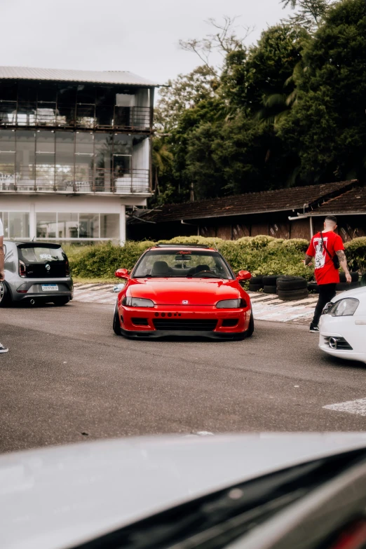 a group of people standing near many parked cars