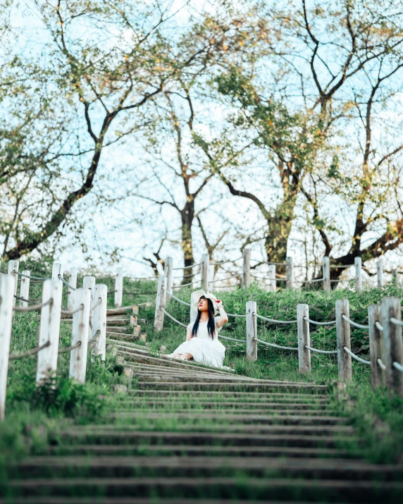 a woman stands on a long set of stairs