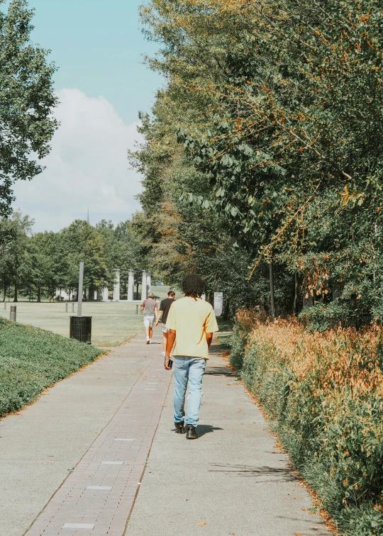 a person in a yellow jacket is walking down a path