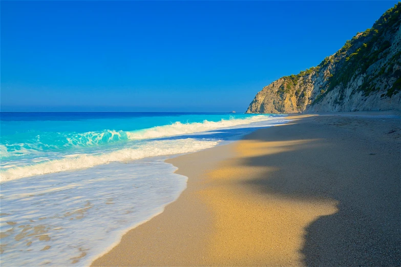 a sandy beach near the shore and a cliff on the shore