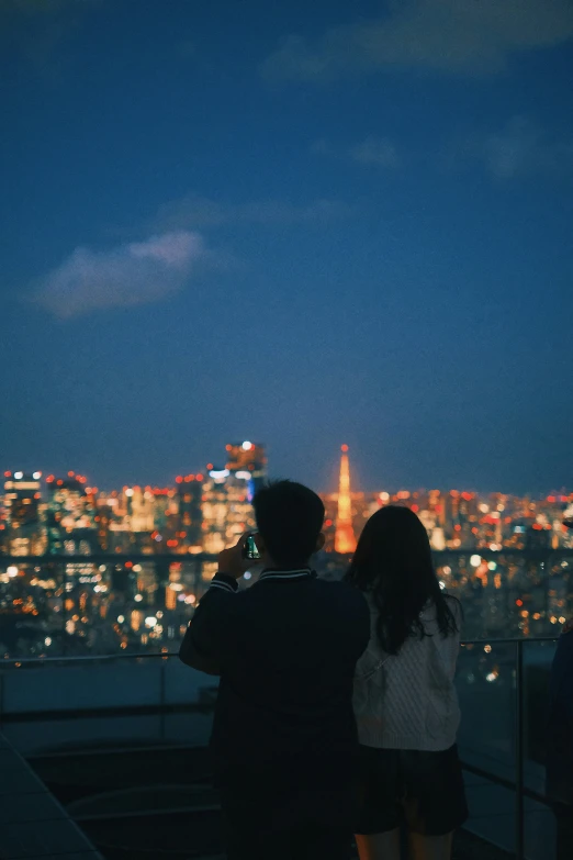 a couple is looking at the city from a tower