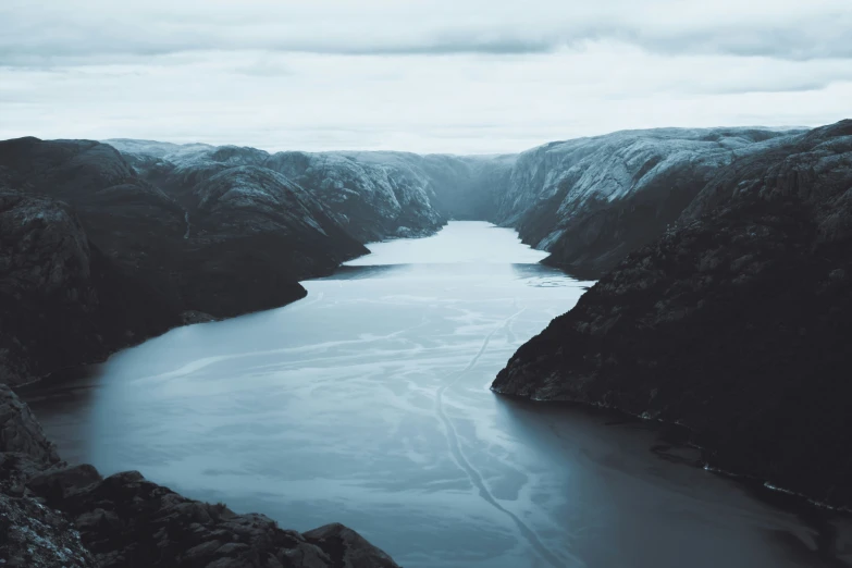 there is a lake surrounded by hills and ice in the water