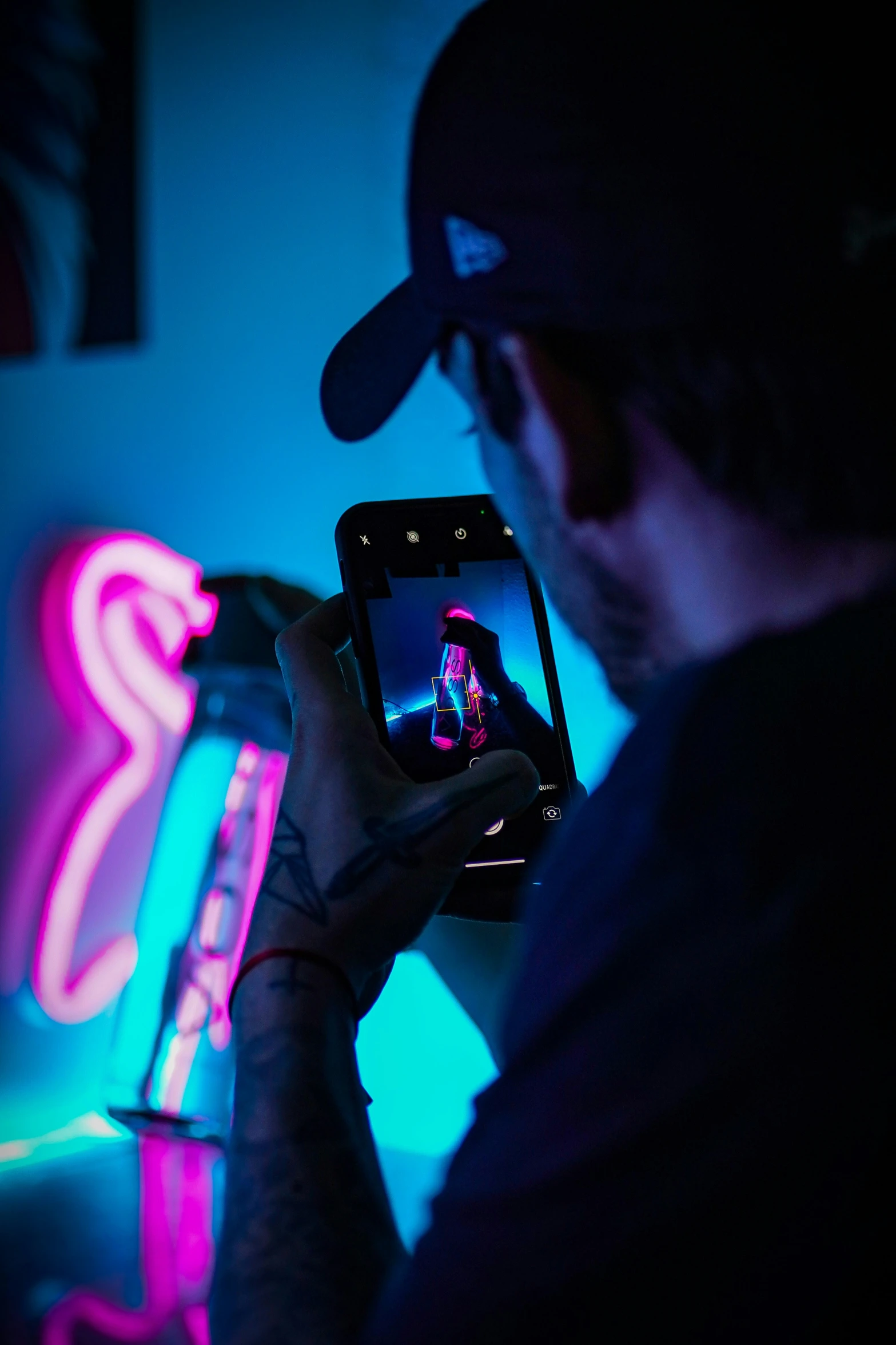 a man with a cap on and the lights on and a cell phone in his hands