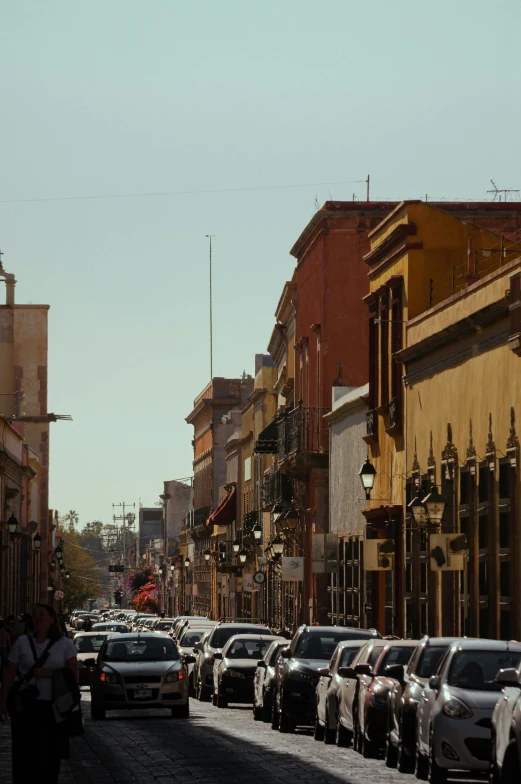 a street is full of vehicles, people and buildings