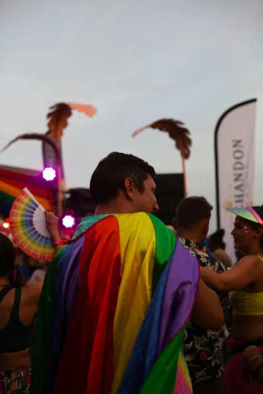 people wearing colorful clothing in the street with palm trees