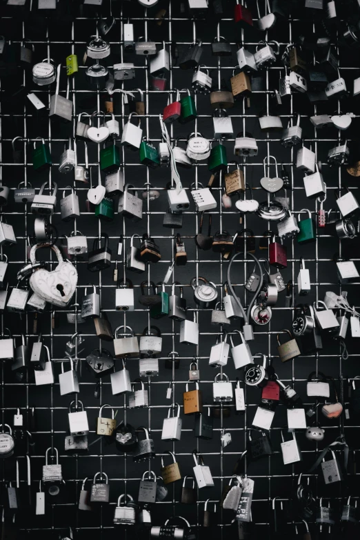 wall covered in several rows of small pieces of paper hanging on hooks