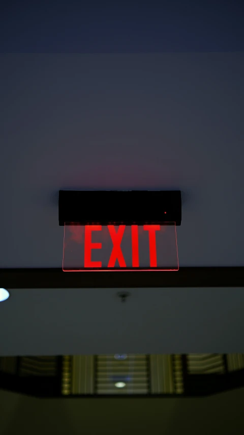 a red exit sign sitting above a door way