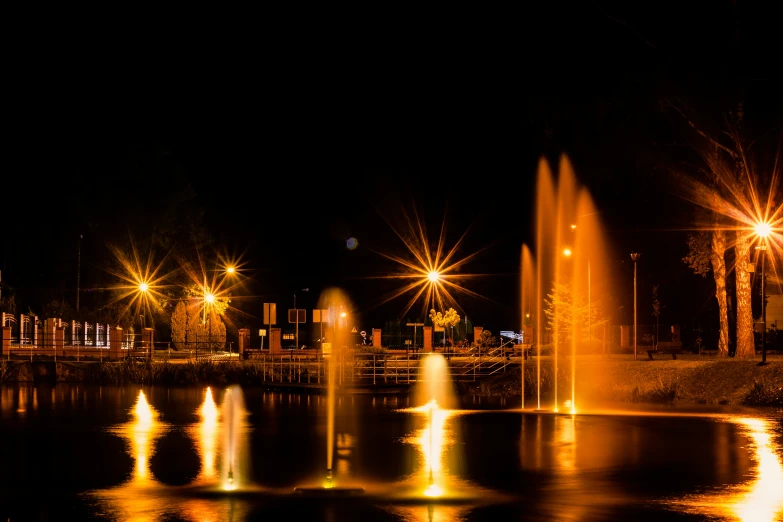 a lighted display of fountains in the middle of a lake