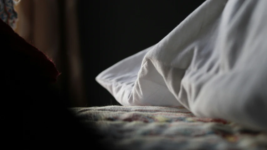 a close up of a pillows and covers on a bed