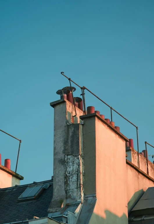 a rooftop with metal railings and roof vents