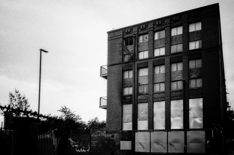 a large building with many windows near a tall fence