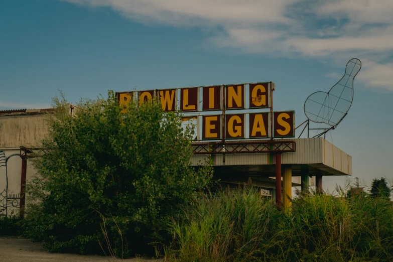 a sign advertising bowling and vegass in front of an old barn