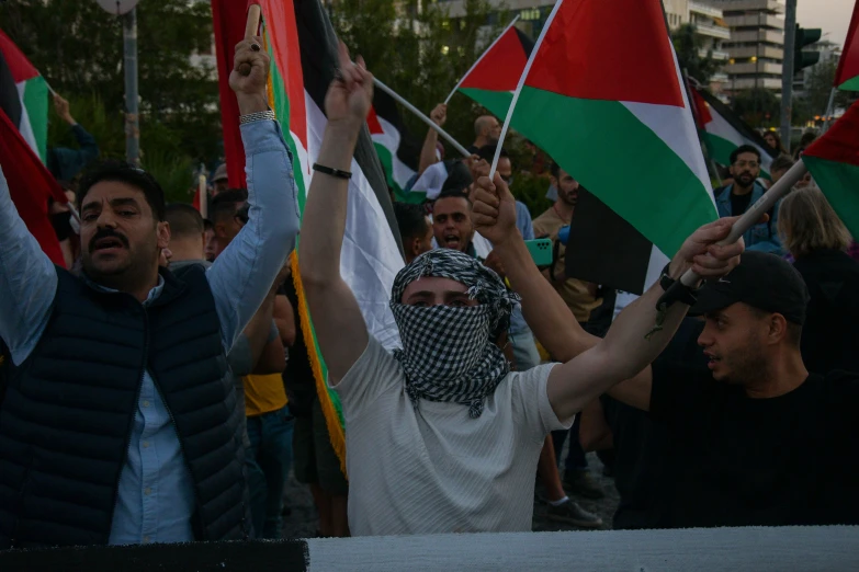 a person with a face covered holding up several flags