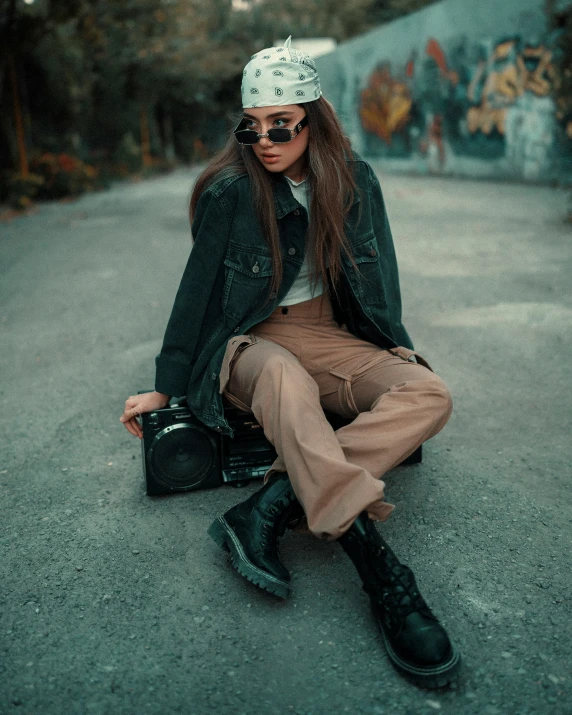 a person is sitting on the ground wearing a hat and sunglasses