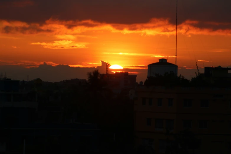 the sun setting over the city skyline over buildings