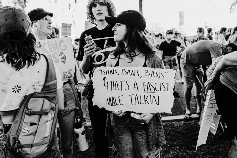 people standing in a crowd, each holding a sign