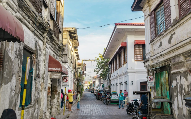 a very narrow street with a lot of houses and people