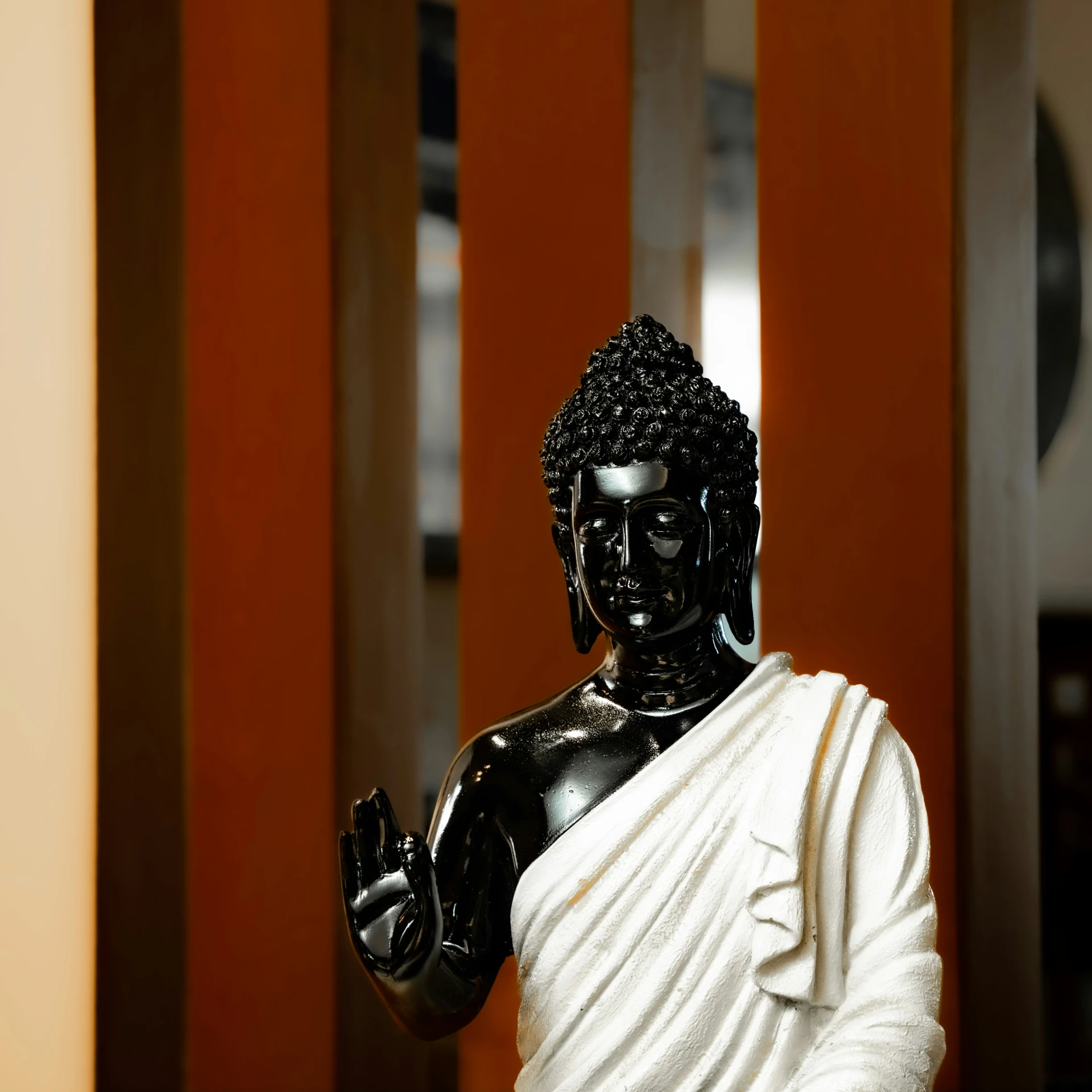 black statue of buddha in front of large pillars